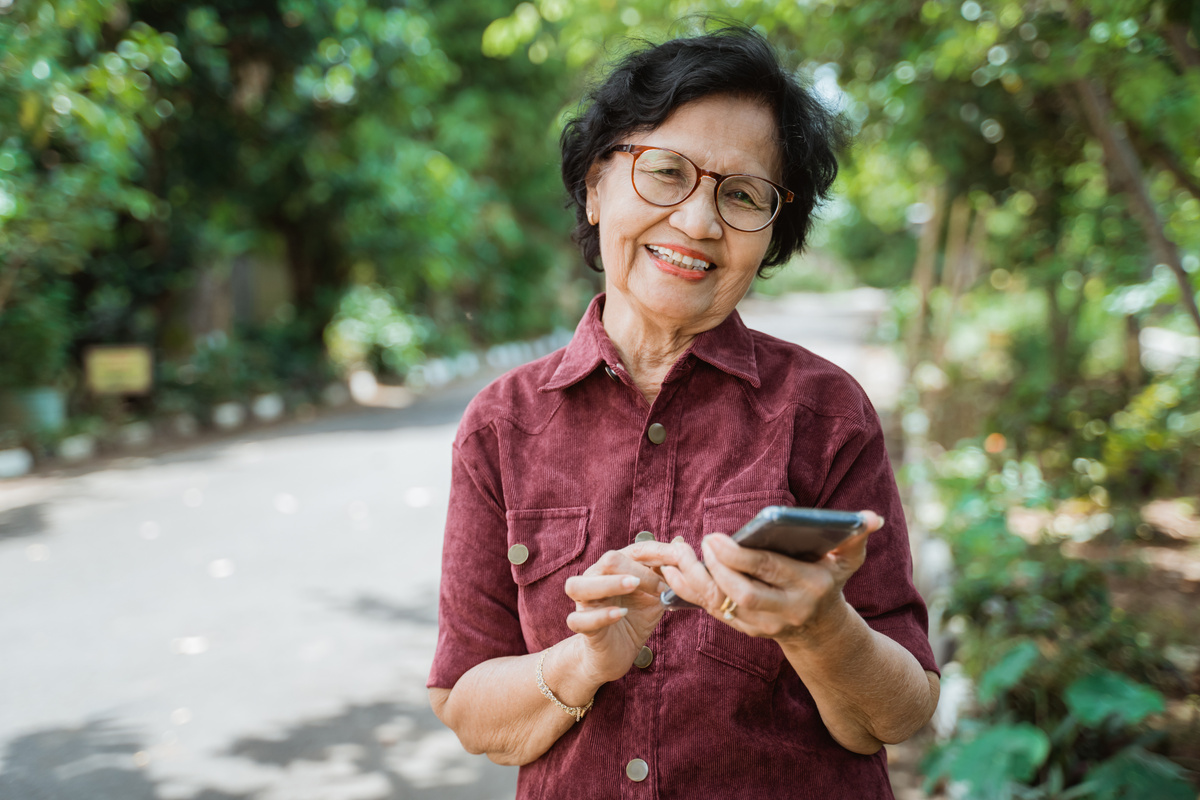Smiling Old Woman Using a Smartphone